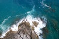 Aerial view Drone camera top down of seashore rocks in a blue ocean Turquoise sea surface Amazing sea waves crashing on rocks Royalty Free Stock Photo