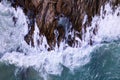 Aerial view Drone camera top down of seashore rocks in a blue ocean Turquoise sea surface Amazing sea waves crashing on rocks Royalty Free Stock Photo