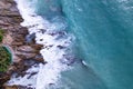 Aerial view Drone camera top down of seashore rocks in a blue ocean Turquoise sea surface Amazing sea waves crashing on rocks Royalty Free Stock Photo