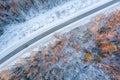 Aerial view from drone of car on curvy snow covered road in the winter forest Royalty Free Stock Photo