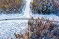 Aerial view from drone of car on curvy snow covered road in the winter forest Royalty Free Stock Photo