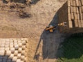 Aerial view from drone large stacks of dry hay bales in the field. Tractor folds bales of hay on a sunny day. Top view Royalty Free Stock Photo