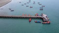 Aerial view from drone of Long bridge in the middle of the sea and colorful local long-tail boats Royalty Free Stock Photo