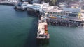 Aerial view from drone of people on fishing pier and tourist cove called La caleta El Membrillo fishing terminal