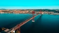 Aerial view or drone photo of the 25 De April Bridge. Red bridge is connecting Lisbon and Almada, Portugal. Tagus river. Royalty Free Stock Photo