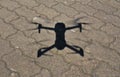 Aerial view on drone shadow on concrete ground, Quadcopter during landing procedure in sunny day