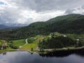 Aerial view, drone shot of Norwegian fjord mountains with green pines and private houses Royalty Free Stock Photo