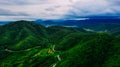 Aerial view or drone shot of road thru mountains with green forest in Asia. Royalty Free Stock Photo