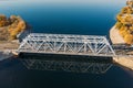 Aerial view drone shot of steel railroad bridge crossing big blue river, train transportation Royalty Free Stock Photo