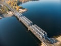 Aerial view drone shot of steel railroad bridge crossing big blue river, train transportation Royalty Free Stock Photo