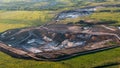 Aerial view from drone to industrial limestone opencast mine Quarry with vehicles and special equipment among green fields