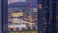 Aerial view of Dubai Fountain in downtown with palms in park next to shopping mall and souq night to day timelapse, UAE