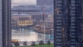 Aerial view of Dubai Fountain in downtown with palms in park next to shopping mall and souq night to day timelapse, UAE