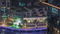 Aerial view on Dubai Marina illuminated promenade with palms ad yachts night timelapse.