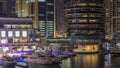 Aerial view of Dubai Marina with shopping mall, restaurants, towers and yachts night timelapse, United Arab Emirates.