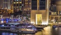 Aerial view of Dubai Marina with shopping mall, restaurants, towers and yachts night timelapse, United Arab Emirates.