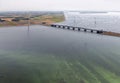 Aerial view Dutch landscape with bridge, wind turbine and algae