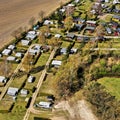 Aerial view of the edge of a campsite with a few cottages, caravans and tents on grassland Royalty Free Stock Photo