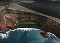 Aerial view of the El lago Verde Lanzarote - green lagoon with huge cliffs and volcanoes on background. Blue Atlantic ocean with