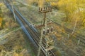 Aerial view on electric train railroad with concrete power supply pole surrounded by yellow spring grass Royalty Free Stock Photo