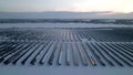 Aerial view of electrical power plant with solar panels covered with snow. Concept of low effectivity of renewable