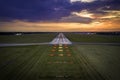 Aerial view on empty airport runaway with markings for landings and all navigation lights ILS Cat II on at the colorful sunset Royalty Free Stock Photo