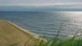 Aerial view empty beach sea shore. Grass blowing wind by crashing ocean waves. Royalty Free Stock Photo