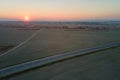 Aerial view of empty intercity road with asphalt surface and white markings in evening Royalty Free Stock Photo