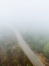 Aerial view of an empty mountain road disappearing into fog Royalty Free Stock Photo