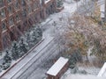 Aerial view of empty road, trees and buildings covered in snow during winter season and first snowfall in city Royalty Free Stock Photo