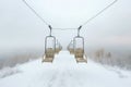 aerial view of empty ski lift chairs over snowy landscape