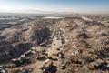 aerial view of enormous landfill, surrounded by rows of trash bags and bins