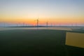 Aerial view of Eolian generators in a beautiful wheat field. Eolian turbine farm. Wind turbine silhouette. Wind mill turbines. Wi