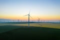 Aerial view of Eolian generators in a beautiful wheat field. Eolian turbine farm. Wind turbine silhouette. Wind mill turbines. Win