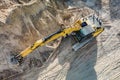 Aerial view of excavator working in quarry or construction site. Industrial top view background concept. A mining excavator is Royalty Free Stock Photo