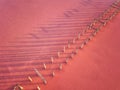 Aerial view of extremely salty lake with wooden logs for salt extraction in the pink water, natural abstract background