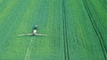 Aerial view Farm machinery spraying chemicals on the large green