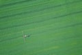 Aerial view Farm machinery spraying chemicals on the large green