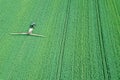 Aerial view Farm machinery spraying chemicals on the large green