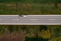 Aerial view of farm tractor hauling fecal tank on country road, drone pov