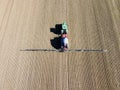 Aerial view farmer fertilizes field with tractor