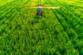 Aerial view of farming tractor plowing and spraying on field