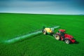 Aerial view of farming tractor plowing and spraying on field