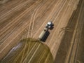 Aerial view of a farming tractor with a trailer fertilizes a freshly plowed agriculural field with manure