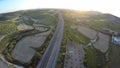 Aerial view of fascinating sunlit agricultural terrains and speed highway