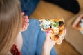 The girl holds an over-eaten piece of salami pizza in her hand. Royalty Free Stock Photo