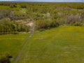 Aerial view of the field with green grass and yellow dandelions without people and garbage with forest and trees. Health and