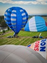 Aerial view of a field with multiple hot air balloons preparing to take off