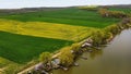 Aerial view of fields of grass by a riverbank with piers