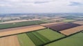 Aerial view of fields with various types of agriculture, against cloudy sky